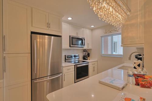 a kitchen with white cabinets and a stainless steel refrigerator at Siesta Key Island Rentals in Siesta Key