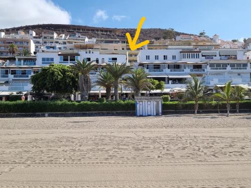 アロナにあるLas Vistas Beachのヤシの木が茂る浜辺の白い大きな建物