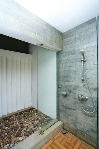 a bathroom with a shower with a glass wall at Super Townhouse Island Inn in Cochin