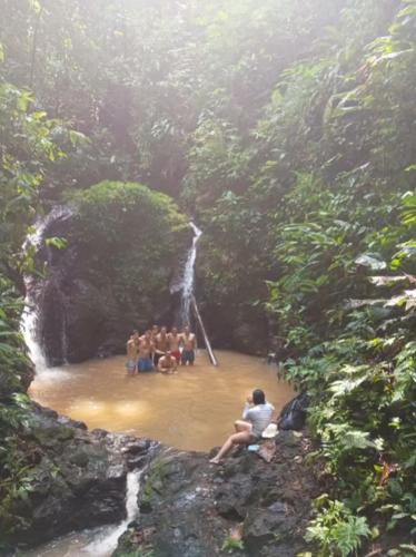 a group of people standing in front of a waterfall at Iracas del Mar in Termales - agua caliente - nuqui