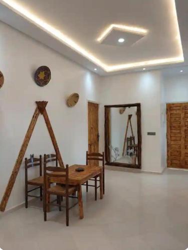 a dining room with a table and chairs and a mirror at Villa chaima in Essaouira