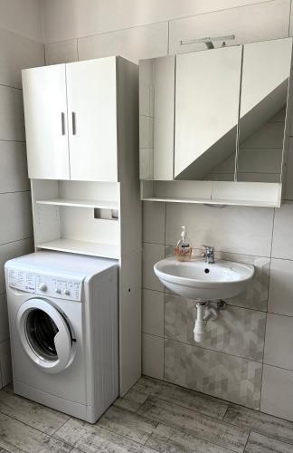 a bathroom with a washing machine and a sink at Kamienica pod Rakiem in Żmigród