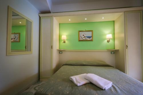 a bedroom with a bed with a pink towel on it at Hotel Rivamare in Ischia