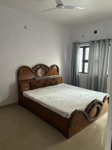 a bedroom with a wooden bed in a room with a window at MOTA HOUSe in Jāmb
