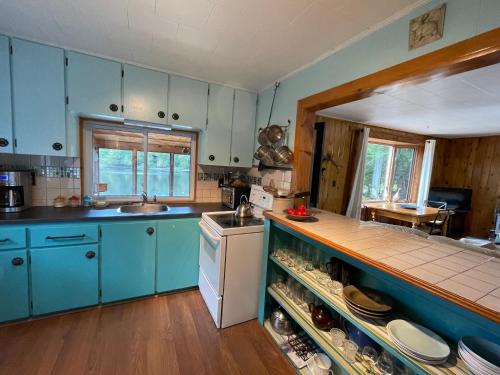 a kitchen with blue cabinets and a counter top at Algonquin Waterfront and Winter Paradise With Sunsets in Algonquin Highlands