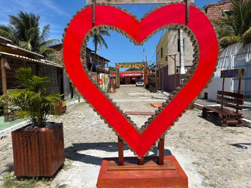 a large red heart statue on a street at Casinha Sol e Mar in Extremóz