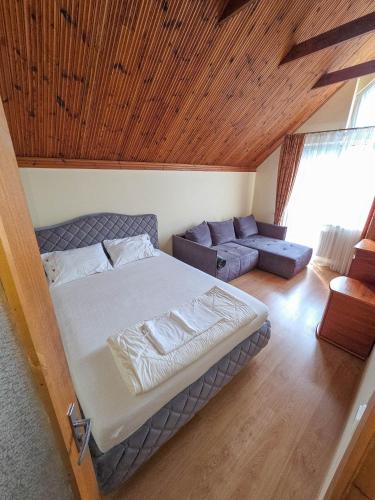 a bedroom with a bed and a couch in a room at Apartamentai Šilas in Druskininkai