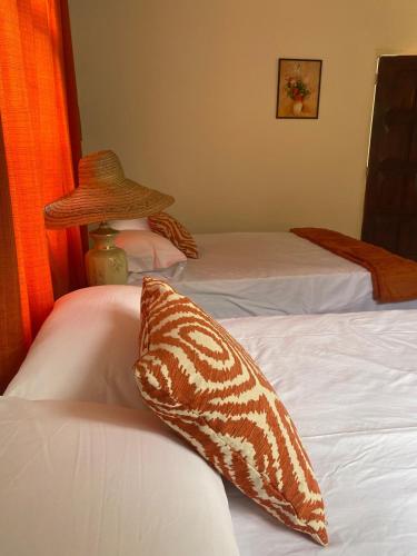 a bedroom with two beds and a hat on top of them at Tangerine Nest in Port Antonio