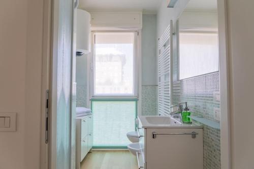 パドヴァにあるArt Home in the heart of Paduaのバスルーム(洗面台、トイレ付)、窓2つが備わります。