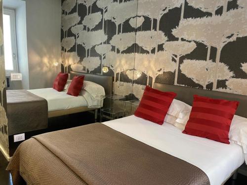 una camera d'albergo con due letti con cuscini rossi di St. Peter Guest House a Roma