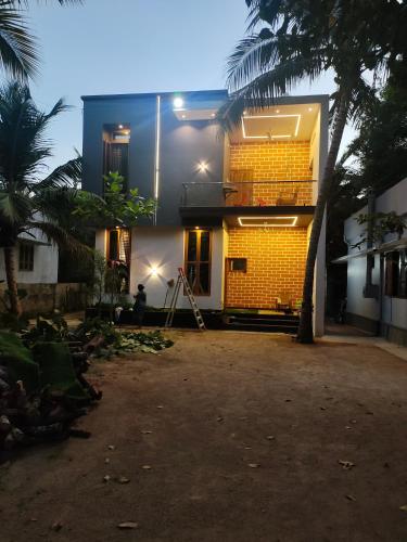 a yellow brick house with a palm tree in front of it at 3bhk luxury Villa in Taingapatam