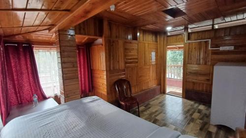 a bedroom with a bed in a wooden room at Ribsweet Treetops Bed and Breakfast in Pynursla