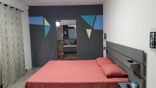 a bedroom with a bed with a red bedspread at Getaway to Mauritius - Évasion à Île Maurice in Eau Bleue