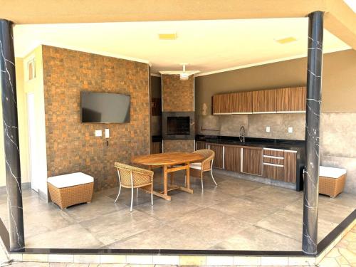 eine Küche und ein Esszimmer mit einem Tisch und einem TV in der Unterkunft Casa dos sonhos na Zona Sul in Ribeirão Preto