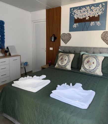 a bedroom with a green bed with two white towels at Mayfair Apartment Ksamil in Ksamil