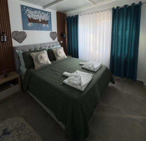 a bedroom with a green bed with towels on it at Mayfair Apartment Ksamil in Ksamil