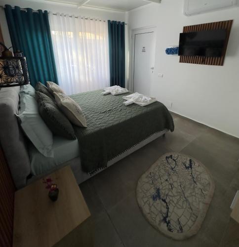 a bedroom with a bed and a television in it at Mayfair Apartment Ksamil in Ksamil
