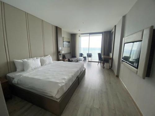 a hotel room with a large bed and a large window at Tropical Ocean Escape Nha Trang in Nha Trang