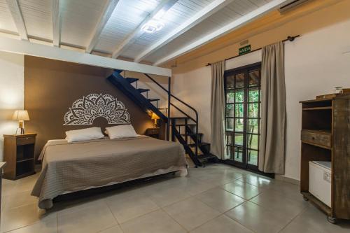 Un dormitorio con una cama y una escalera de caracol. en Pousada Hakuna Matata, en Morretes