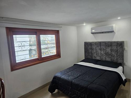 a bedroom with a bed and a window at Guest House with AC, close to Historical Centre 3 in Cartagena de Indias