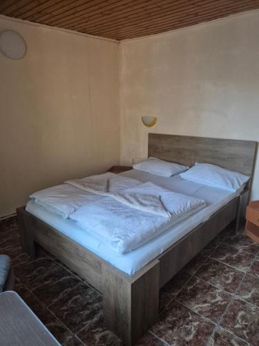 a bedroom with a large bed with white sheets at Cabana Lir in Arad