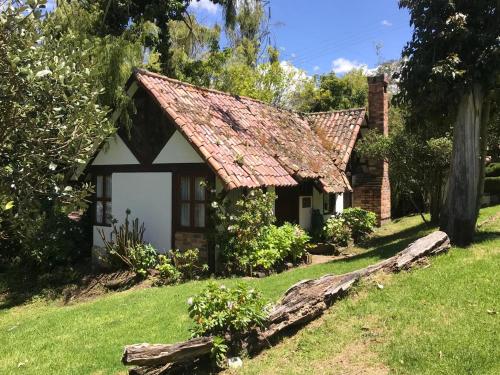 a small house with a rusty roof on a yard at Chalet Andino Sesquile in Suesca
