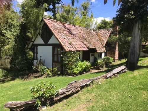 a small house with a red roof on a yard at Chalet Andino Sesquile in Suesca
