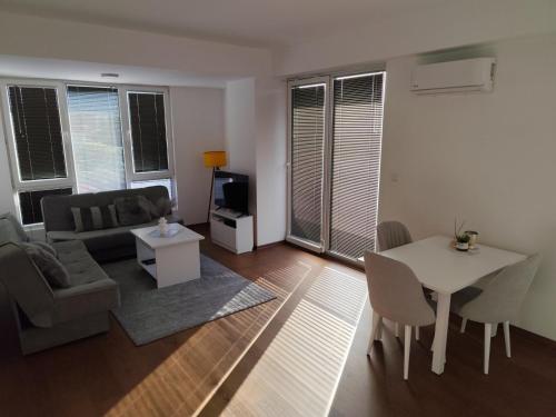 a living room with a couch and a table and chairs at Miha apartment in Petrovec