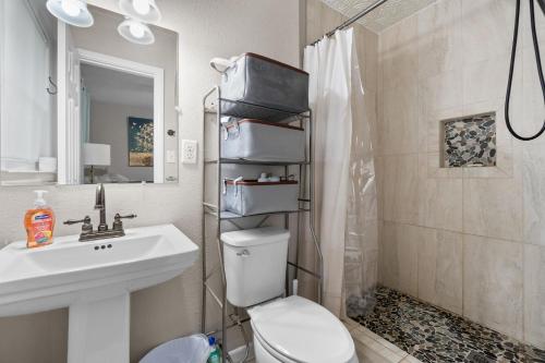 a bathroom with a toilet and a sink and a shower at Escape by Beaches & Blue Angels in Pensacola