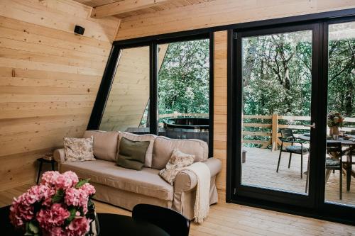 a living room with a couch and a patio at Woodland Noszvaj Moha Kabin in Noszvaj