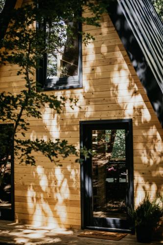a house with the shadows of a tree on it at Woodland Noszvaj Moha Kabin in Noszvaj
