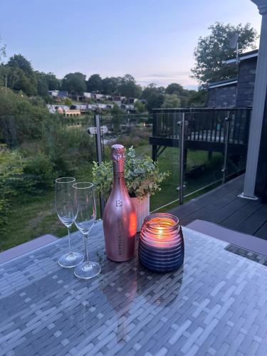 a table with two wine glasses and a bottle at Swan lake lodge in Caernarfon