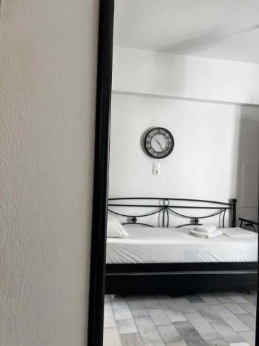 a bedroom with a bed with a clock on the wall at Studio Tsakas in Naxos Chora