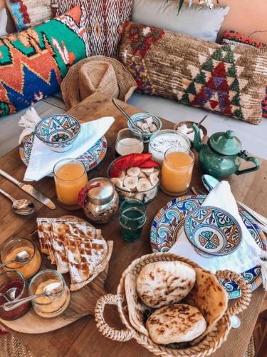 a table topped with plates of food and orange juice at Studio Art Ryad in El Jadida