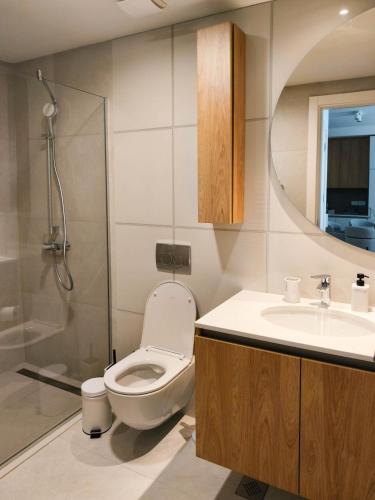 a bathroom with a toilet and a sink and a shower at BW Crown Garden Residences in Sajmište