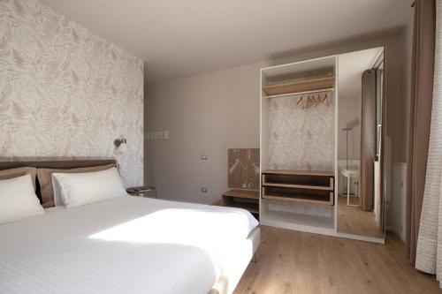 Un dormitorio con una cama blanca y una ventana. en Oltremodo - Bed and Breakfast, en Tolentino