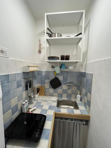 a small kitchen with a sink and blue and white tiles at Casa A'Bareis in Polignano a Mare