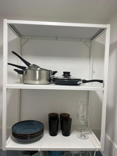 a shelf with a pot and plates and a wine glass at Casa A'Bareis in Polignano a Mare
