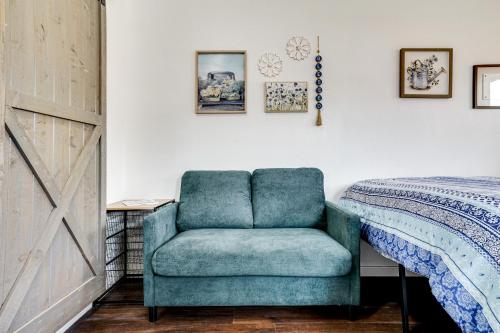 a bedroom with a blue chair next to a bed at Cozy Country Living Cabin in SlidellandDecatur! in Decatur