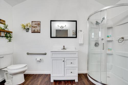 a white bathroom with a toilet and a shower at Cozy Country Living Cabin in SlidellandDecatur! in Decatur
