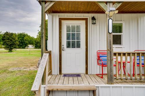 a porch with a white door and a red chair at Cozy Country Living Cabin in SlidellandDecatur! in Decatur