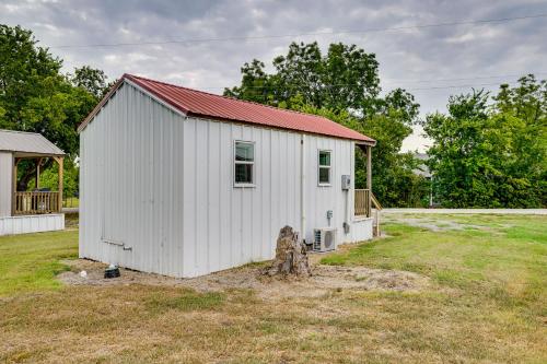 a white shed with a red roof in a field at Cozy Country Living Cabin in SlidellandDecatur! in Decatur