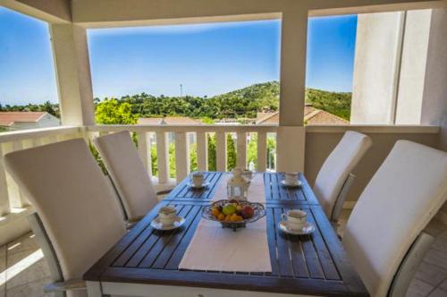 a table with a bowl of fruit on a balcony at Župa Dubrovačka Guest House in Mlini