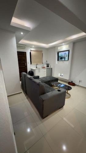 a living room with a couch and a kitchen at Made Stays in Four Ways