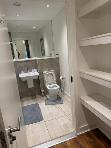 a bathroom with a toilet and a sink at AA Apartment in Barking