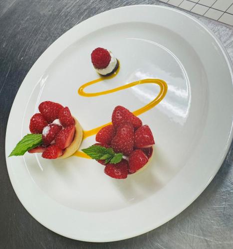 a plate with strawberries and a dessert on it at Hotel & Restaurant Forni in Airolo
