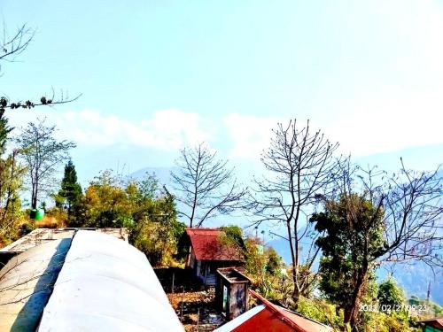 a train on a track with trees and mountains in the background at Shanti kunj a unit of 'THE NOOK' Mangkhim in Aritar