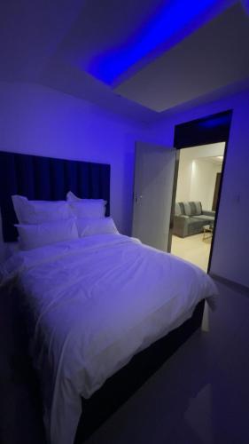 a bedroom with a large white bed with purple lights at Made Stays in Four Ways
