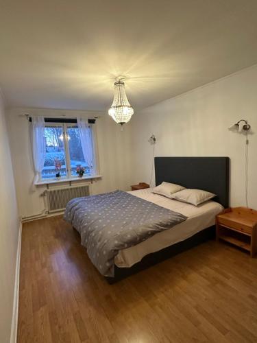 a bedroom with a large bed and a chandelier at Grevgatan 4 in Eksjö