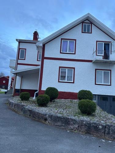 a white and red house with bushes in front of it at Grevgatan 4 in Eksjö